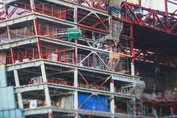Fototapeta na wymiar A large construction site in the city, the process of massive skyscraper building construction with heavy vehicle at work