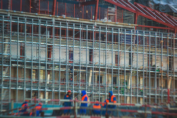 A large construction site in the city, the process of massive skyscraper building construction with heavy vehicle at work