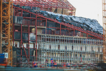 A large construction site in the city, the process of massive skyscraper building construction with heavy vehicle at work