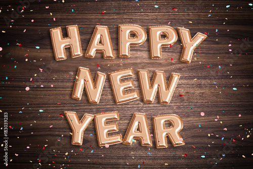&quot;Luftballons formen den Spruch &quot;Happy New Year&quot; auf Holzuntergrund mit Konfetti&quot; Stockfotos und