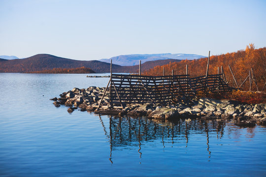 Beautiful vibrant fall autumn landscape of national park near border of Finland, Sweden and Norway, with mountains, camping place, road and forest