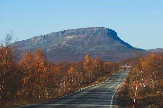 Beautiful vibrant fall autumn landscape of national park near border of Finland, Sweden and Norway, with mountains, camping place, road and forest
