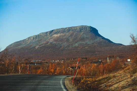 Beautiful vibrant fall autumn landscape of national park near border of Finland, Sweden and Norway, with mountains, camping place, road and forest