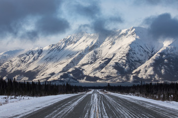 A view down the Alaska Highway towards large mountains