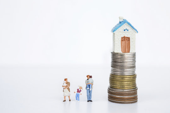 Business concept, Miniature family with stack of coins with miniature house on top, property and real estate business concept
