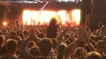 Happy crowd chanting song lyrics and enjoying favorite boys band performance