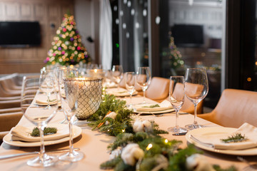Christmas dinner feast. A decorated dining table with champagne glasses and christmas tree in background