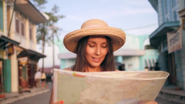 Young Mixed Race Girl Using City Map and Walking Down the Street with Old Buildings. 4K, Slowmotion.