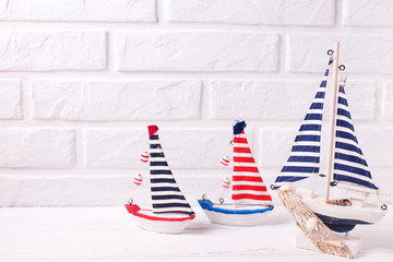 Decorative  wooden toys boats on white wooden background.