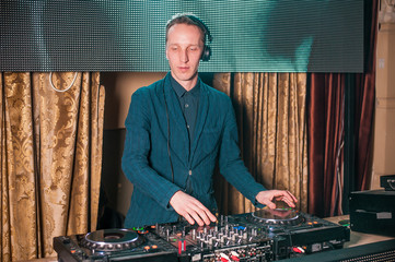 Dj at work in luxury nightclub during night party. Dj make party time at elite night club. Man at...