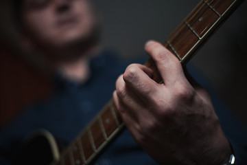 The Guitarist Guy plays the guitar in a bar in a beautiful setting on a high bar stool
