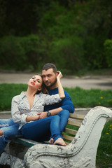 young loving couple relaxing in the Park. man and woman sitting on an old bench in the open air