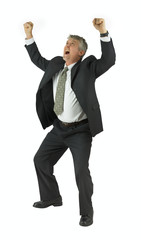 Extremely happy handsome business man in black suit looking up and smiling with arms raised victoriously as he happily yells isolated on white background.