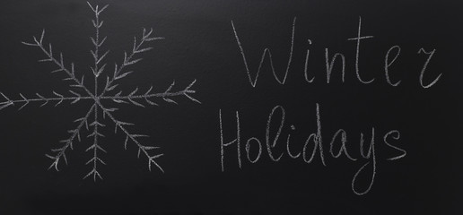 drawn snowflake on blackboard with text: Winter Holidays
