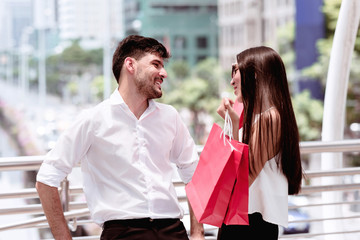 Couple argue after a hard day of huge sale shopping in asian country.