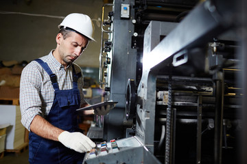 Modern technician with touchpad consulting online recommendations about repairing industrial...