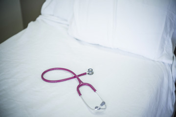Medical stethoscope resting on a hospital bed. Selective focus on the medical device. Generic abstract image