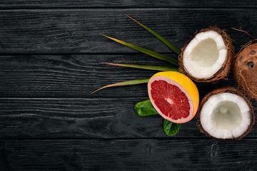 Coconut and grapefruit. Fresh fruits. On a wooden background. Top view. Free space for text.