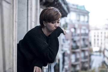 Fototapeta na wymiar young beautiful woman thinking and feeling sad suffering depression at urban city background home balcony