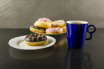 Chocolate doughnut and a mug of coffee on the desk.