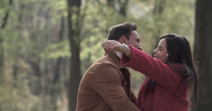Loving couple in autumn forest park 4k slow-motion video. Young man and overweight fat woman embrace hug spin romantic date. Love story romance concept