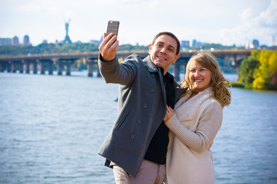 Happy traveling middle age couple making selfie city background , sunny spring or autumn colors, romantic mood. Stylish pretty people. Happy laughing emotional faces.