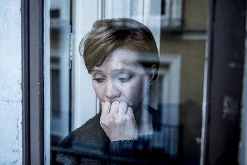 dramatic close up portrait of young beautiful woman thinking and  feeling sad suffering depression...