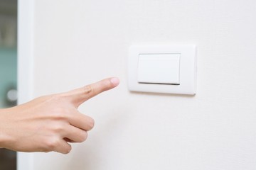 Turn off the light, close up man hand is closing the power switch. Save energy, reduce global warming.