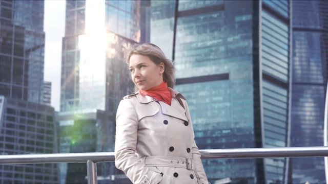 Attractive blonde woman in fashionable clothing answers the long awaited call on the background of skyscrapers, 4K