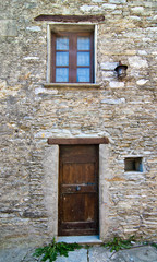 wooden door with window in an old stone building