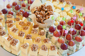 Cheese platter with walnuts and grapes on picks 