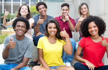 Large group of pretty international young adults showing thumb up