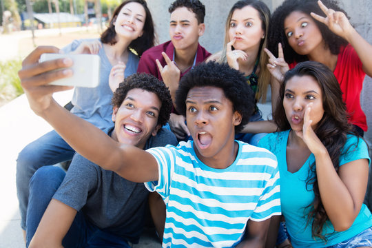 Group of young adults making funny selfie shots with phone