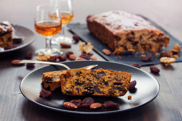 fruit cake on black plate on brown wooden background