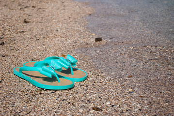 green sea wave mint sneakers of rubber with bows and rhinestones beach slippers on the shore of the...