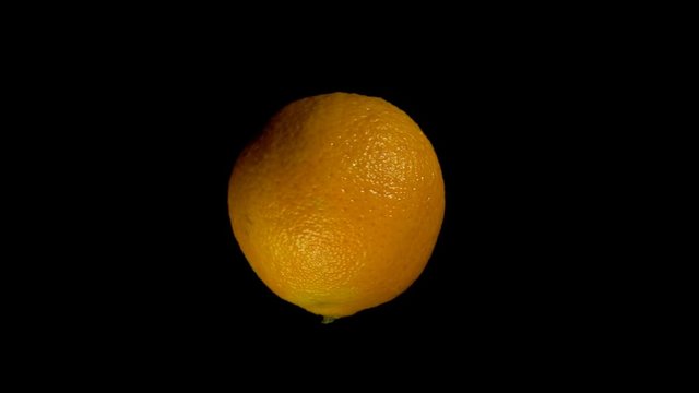 Close-up rotation orange tangerine, fresh citrus isolated on black background.