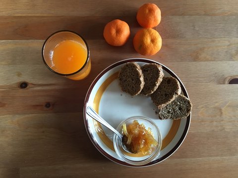 colazione biologica con pane nero marmellata e spremuta fresca
