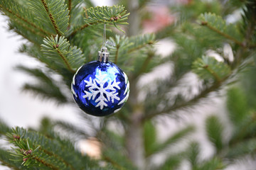 Boule de Noël bleu à flocon blanc dans sapin vert