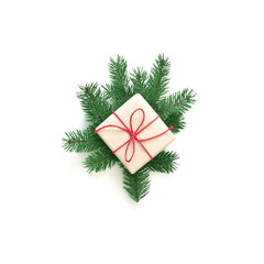 Christmas fir tree branches with gift box on white background with copy space for text.