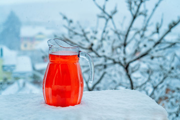 Red, icy drink standing in snow. Christmas Morning Concept