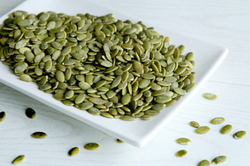 Raw pumpkin seeds. Green unshelled pumpkin seed in plate.
