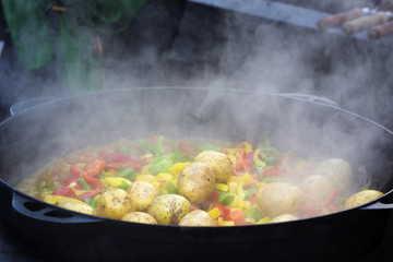 Cooking vegetables in large cast iron cauldron