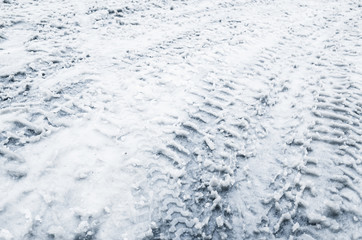 Car tracks on a wet snowy road, closeup