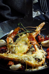 Garnelen mit Käse überbacken in einr Eisenpfanne mit geschmolzenen Tomaten und Knoblauch