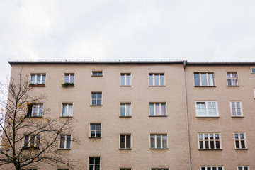 Fototapeta na wymiar old brown gdr plattenbau building on a cloudy day in berlin