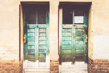 old green vintage doors on grudge facade