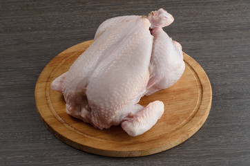 Raw chicken on board wooden background