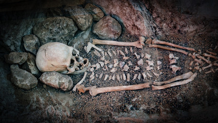 Skeleton of a primitive man inside a cave.