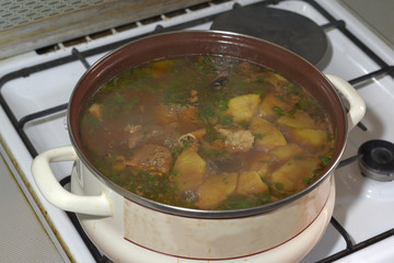 delicious lamb soup, boiling on the kitchen stove in the white pan. The famous Azerbaijan dishes