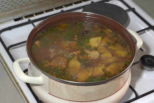 delicious lamb soup, boiling on the kitchen stove in the white pan. The famous Azerbaijan dishes